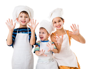 Three young chefs with raised hands in flour, isolated on white