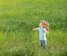 Happy child outdoors in spring field